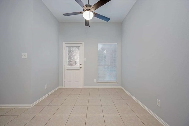 tiled spare room featuring ceiling fan