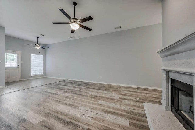 unfurnished living room with light wood-type flooring and ceiling fan