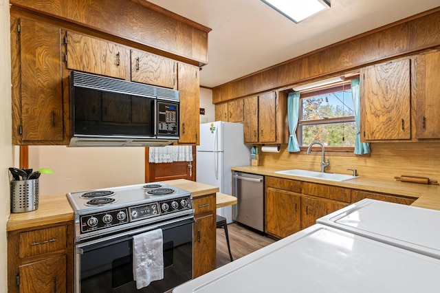 kitchen with light hardwood / wood-style flooring, stainless steel dishwasher, sink, and electric range oven