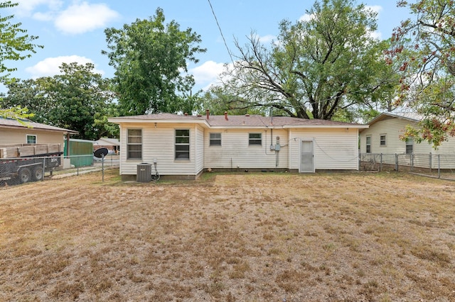 rear view of property with a yard and central AC