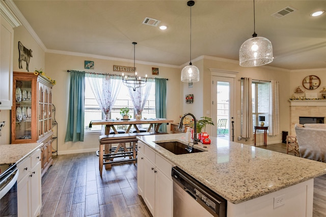 kitchen with an island with sink, sink, white cabinetry, stainless steel appliances, and dark hardwood / wood-style flooring