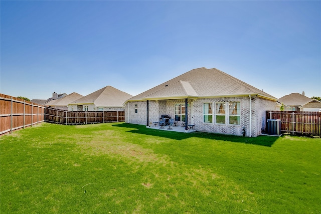 back of house featuring a lawn, cooling unit, and a patio