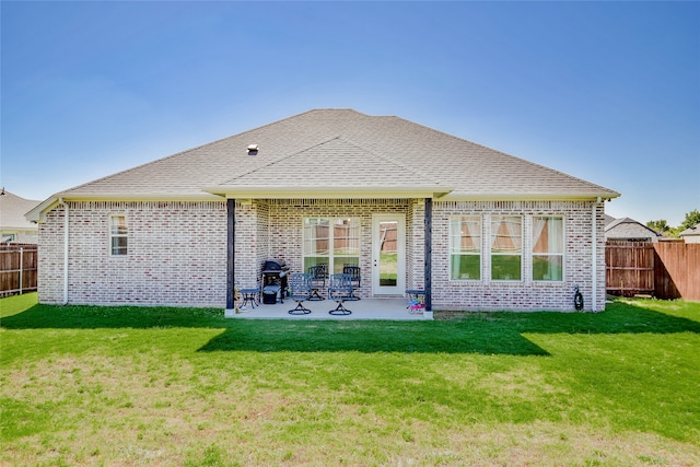 rear view of property with a patio and a lawn