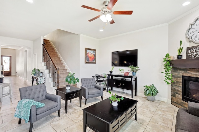 living room featuring ceiling fan, ornamental molding, light tile patterned floors, and a fireplace