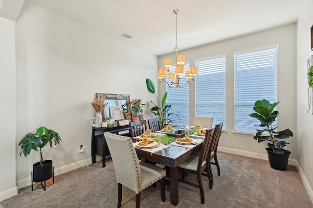 dining room with carpet flooring and a chandelier