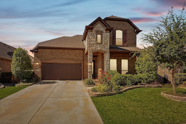 view of front of property featuring a garage and a lawn