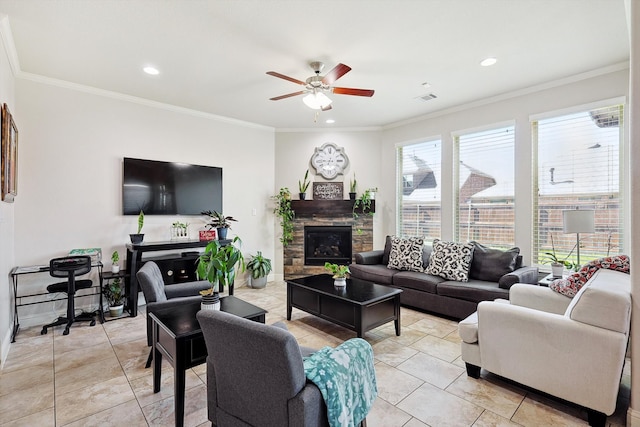 living room featuring crown molding, a stone fireplace, and ceiling fan