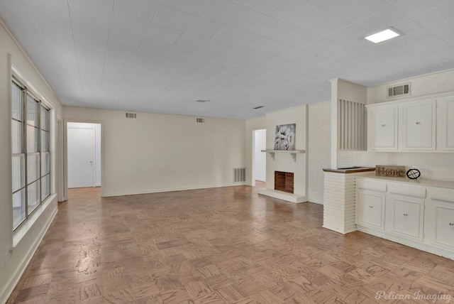 unfurnished living room featuring light parquet flooring and a fireplace