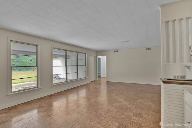 unfurnished living room featuring light parquet flooring and a fireplace