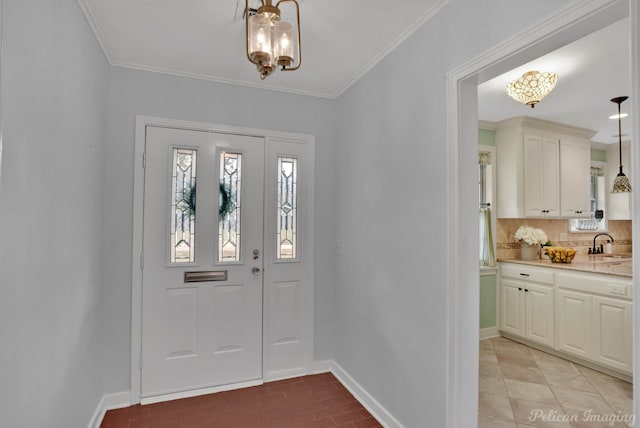 entrance foyer featuring an inviting chandelier, ornamental molding, and sink