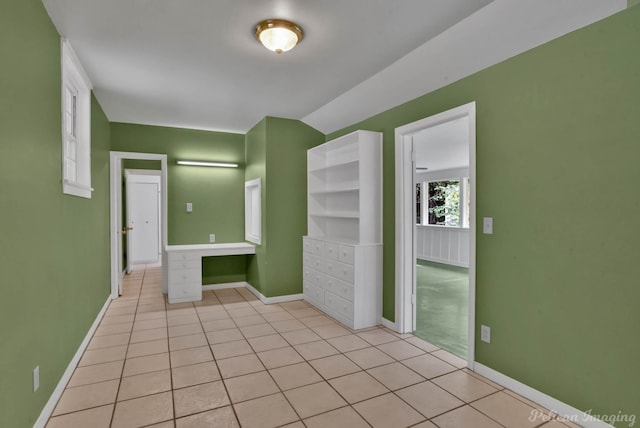 tiled spare room featuring built in desk