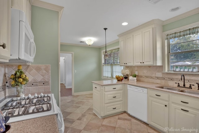 kitchen with tasteful backsplash, sink, pendant lighting, and white appliances