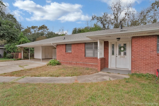 single story home with a front yard, covered porch, and a carport