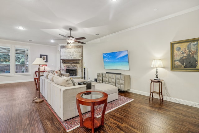 living room featuring dark hardwood / wood-style floors, a stone fireplace, ceiling fan, and ornamental molding