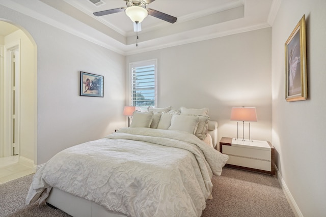 bedroom featuring light colored carpet, a raised ceiling, ceiling fan, and ornamental molding