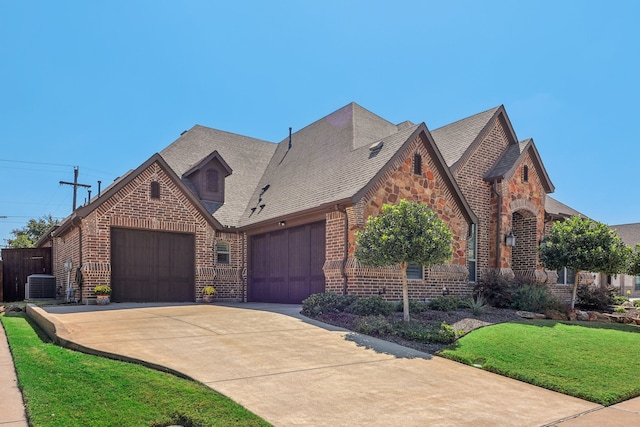 tudor home featuring central AC and a front lawn