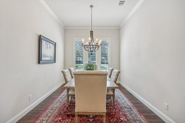 dining area featuring dark hardwood / wood-style flooring, an inviting chandelier, and ornamental molding