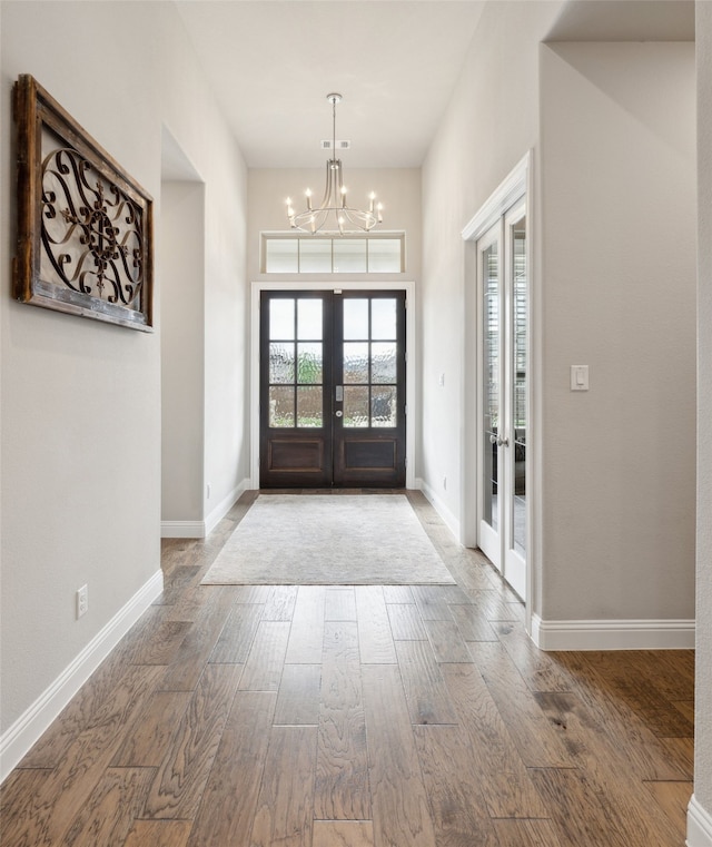 entryway featuring a chandelier, french doors, and wood-type flooring