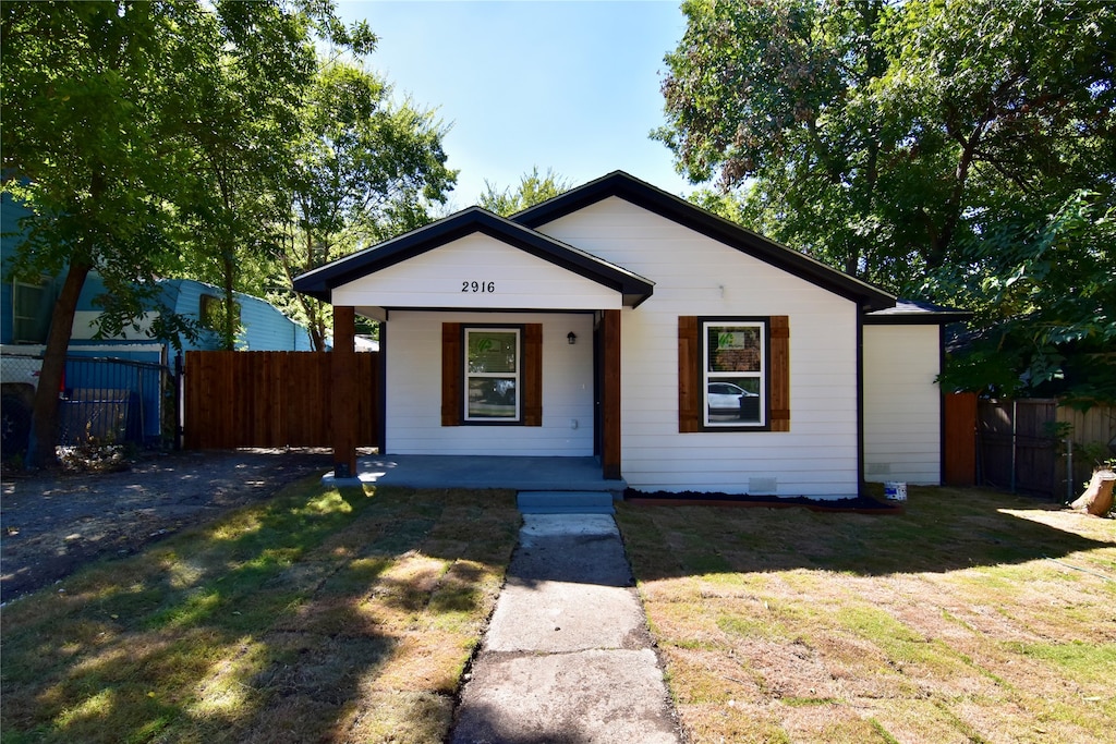 view of front of property with covered porch and a front yard