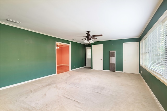 carpeted spare room featuring crown molding and ceiling fan