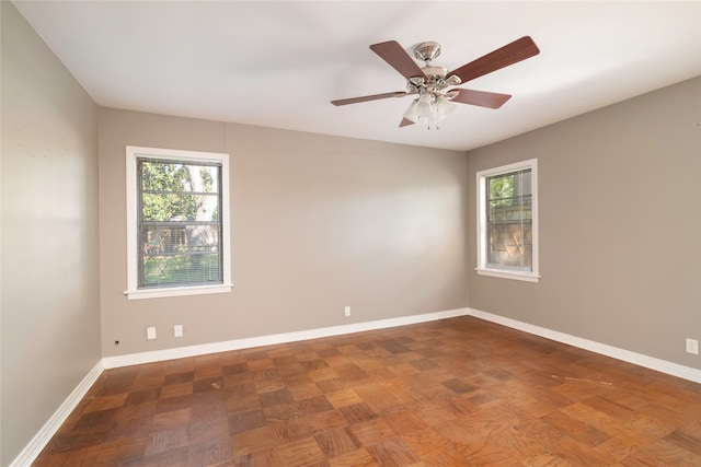 spare room featuring ceiling fan and a wealth of natural light