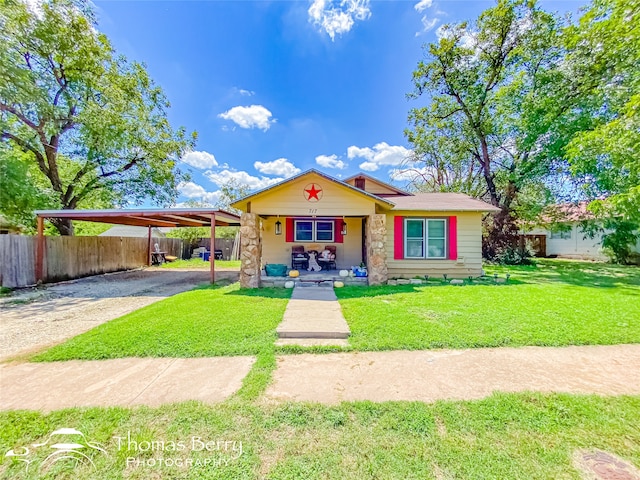 view of front of property with covered porch, a carport, and a front yard