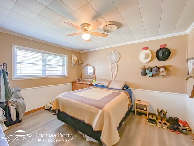 bedroom with ceiling fan, hardwood / wood-style floors, and crown molding