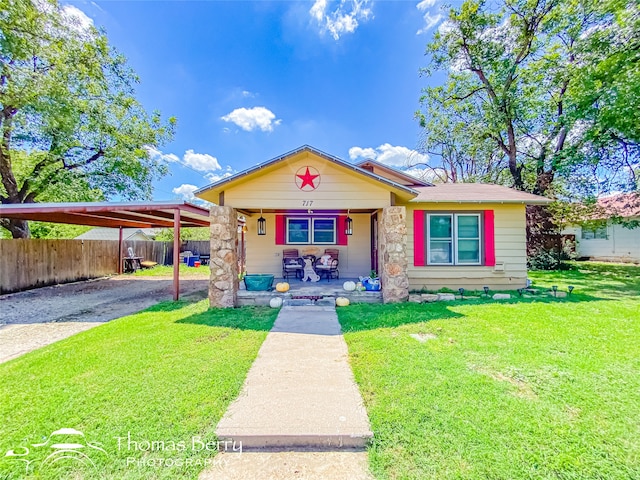 view of front of home featuring a carport, a porch, and a front lawn