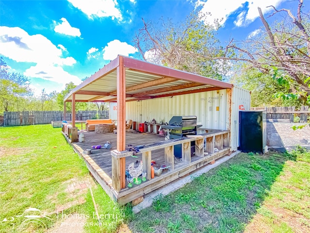 wooden terrace with a lawn and a grill