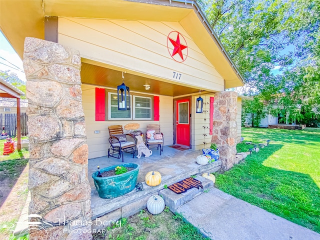 property entrance featuring covered porch and a lawn