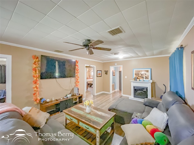 living room with hardwood / wood-style floors, ceiling fan, and crown molding