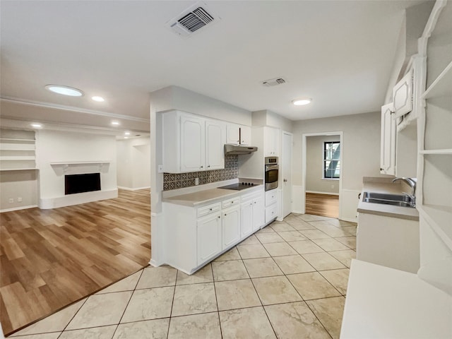 kitchen with sink, light hardwood / wood-style floors, oven, and white cabinetry