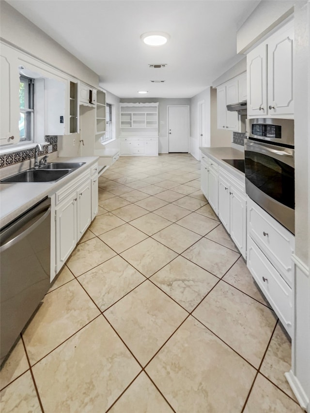 kitchen with white cabinetry, appliances with stainless steel finishes, light tile patterned floors, and sink