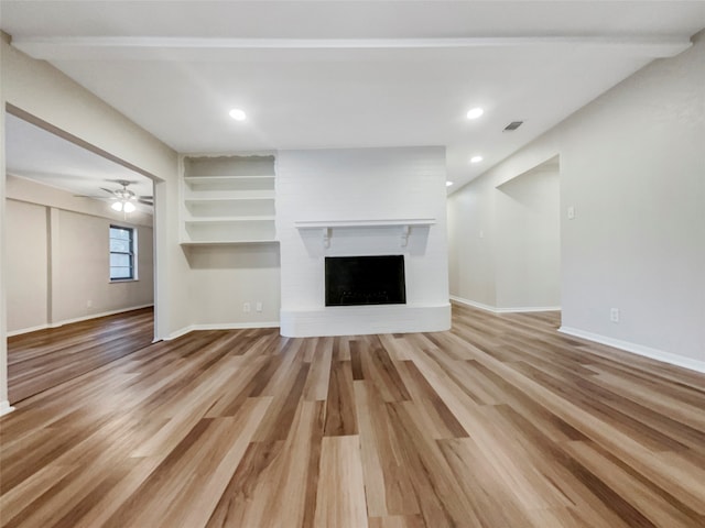 unfurnished living room with wood-type flooring, a fireplace, and ceiling fan