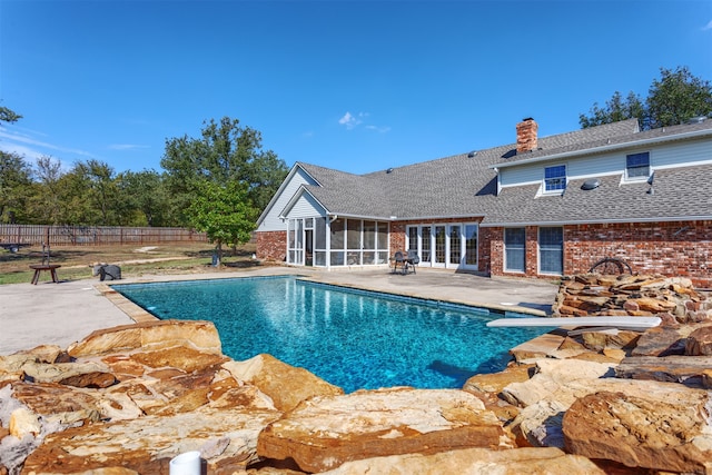 view of pool featuring a sunroom and a patio area