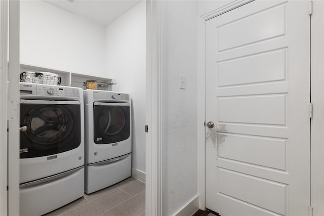 laundry area featuring light tile patterned flooring and washing machine and dryer