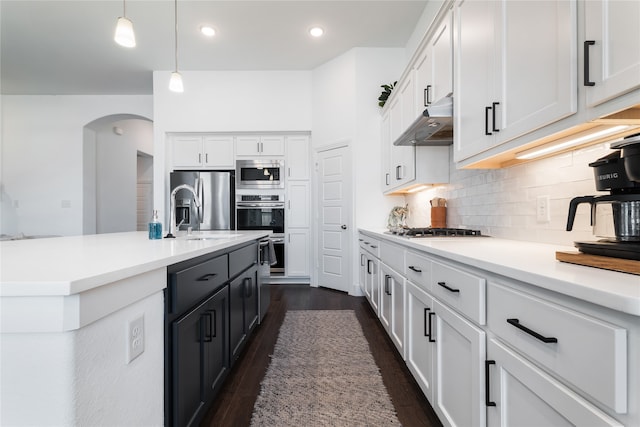 kitchen with white cabinetry, sink, hanging light fixtures, stainless steel appliances, and dark hardwood / wood-style floors