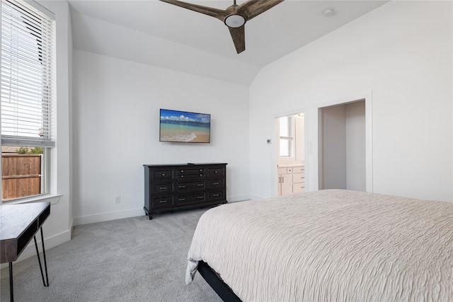 bedroom with light carpet, ensuite bath, ceiling fan, and lofted ceiling