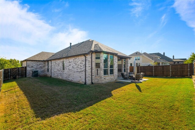 rear view of house featuring a lawn and a patio