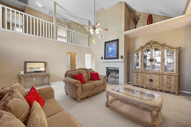 living room with high vaulted ceiling, a tiled fireplace, light carpet, and ceiling fan