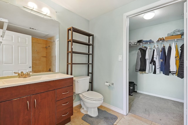 bathroom with tile patterned floors, vanity, tiled shower, and toilet