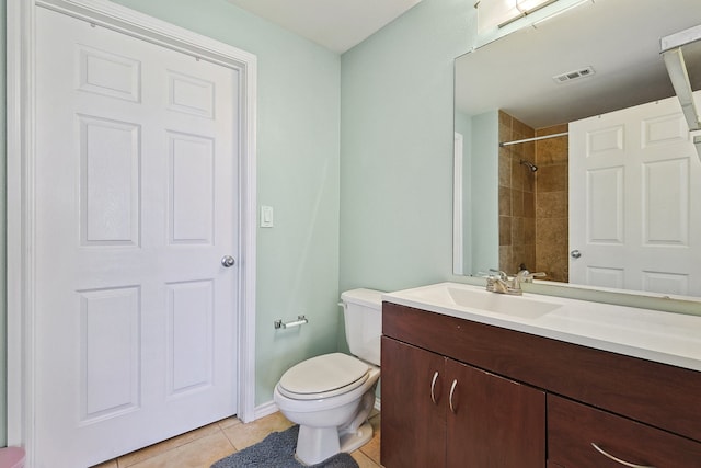 bathroom with toilet, vanity, and tile patterned floors