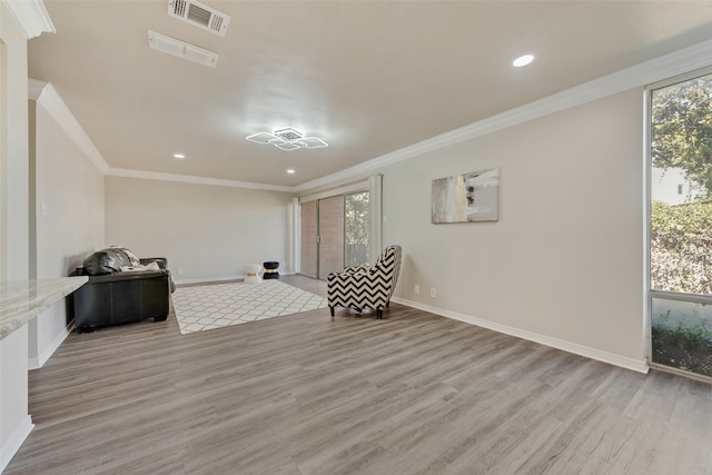 sitting room with light wood-type flooring and ornamental molding