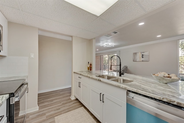 kitchen with sink, stainless steel dishwasher, light hardwood / wood-style flooring, white cabinetry, and decorative backsplash