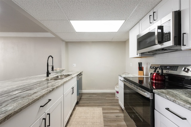 kitchen featuring light stone counters, sink, white cabinetry, stainless steel appliances, and light wood-type flooring