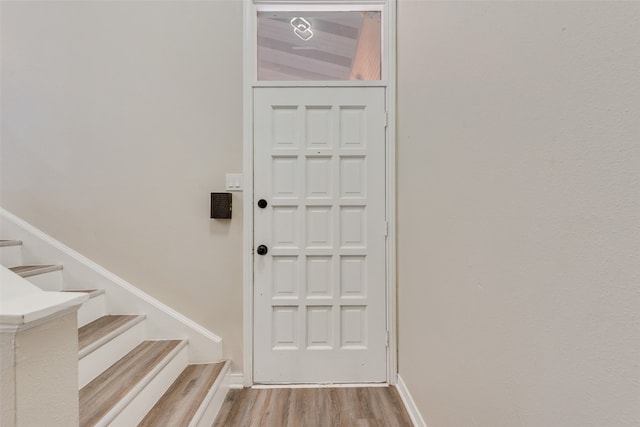 entryway featuring vaulted ceiling and light hardwood / wood-style flooring