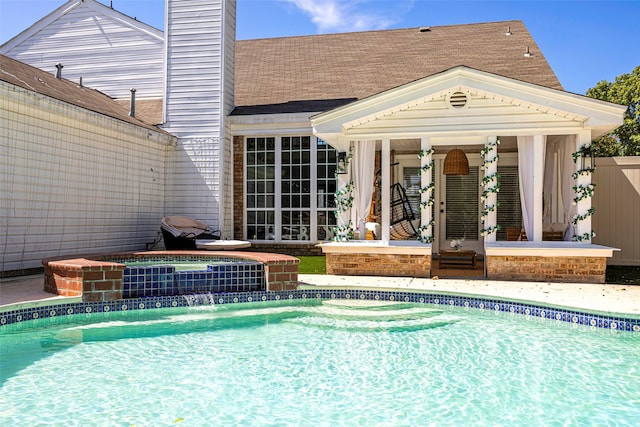 view of pool with an in ground hot tub