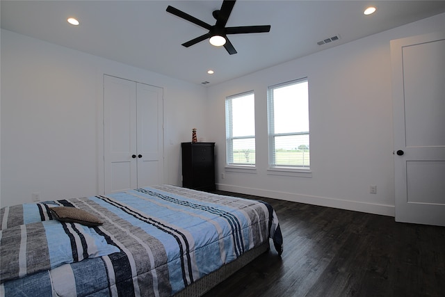 bedroom featuring dark hardwood / wood-style floors, ceiling fan, and a closet