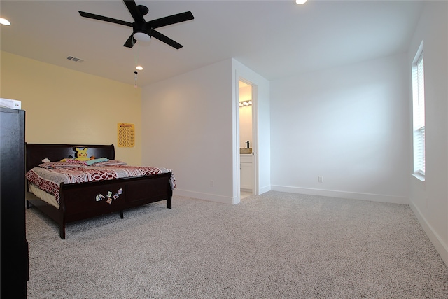 bedroom with ensuite bath, ceiling fan, and light colored carpet