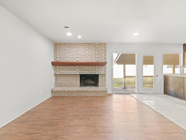 living room featuring light wood-type flooring and a fireplace